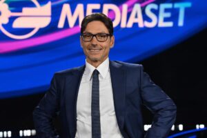 Pier Silvio Berlusconi con il logo Mediaset dietro